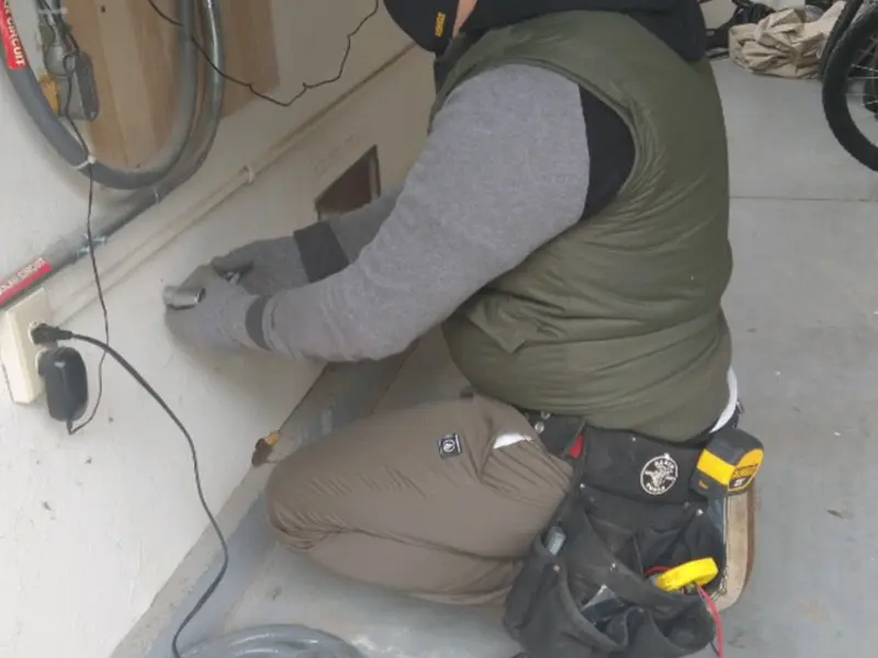 Electrician performing outlet wiring in a Crane garage